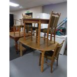 An oval blond oak dining table together with a circular blond oak dining table with extension