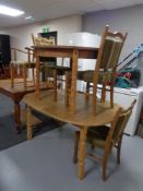 An oval blond oak dining table together with a circular blond oak dining table with extension