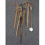 A bundle of eight antique and later walking sticks together with a shooting stick.