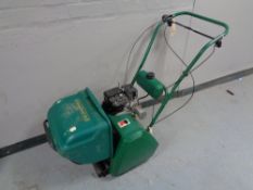A Qualcast classic petrol 35S lawn mower together with a boxed lawn scarifier cassette.
