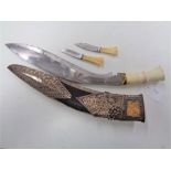 A kukri knife in white metal and leather sheath, blade 30cm.