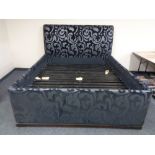 A 6ft bed frame upholstered in a black and silver fabric.