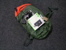 A box containing Belkin cassette adapters, a Thule backpack, Practika camera,