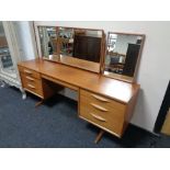A mid 20th century teak Austin suite kneehole dressing table with triple mirror (A/F).