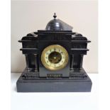 A 19th century German black slate half hour striking mantel clock with brass and enamel dial and