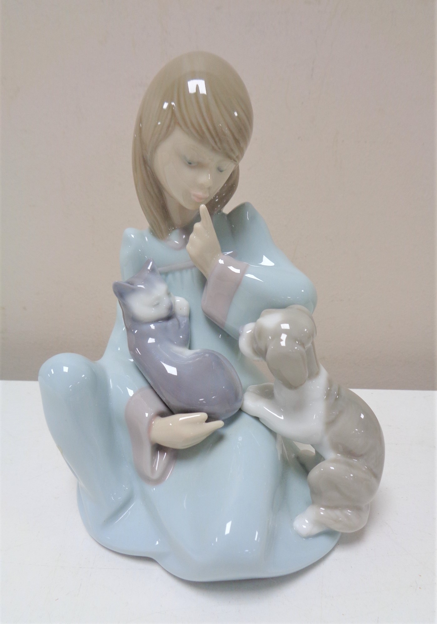 A Lladro figure of a girl seated with puppy and cat number 5640