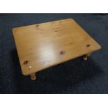 A rectangular pine low coffee table.