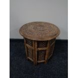 A carved eastern hardwood folding table.