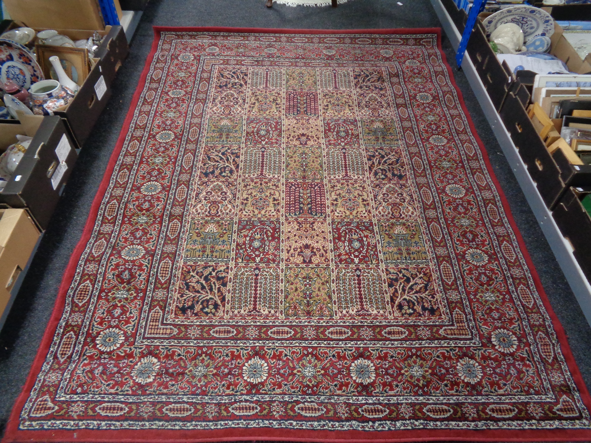 A machine made floral rug on red ground.