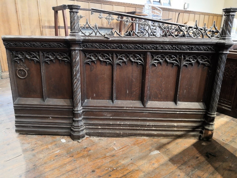 A two section end panel in Gothic revival carved oak, height 102 cm to the rail,