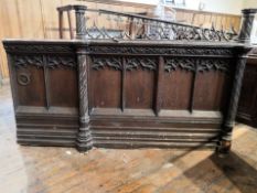 A two section end panel in Gothic revival carved oak, height 102 cm to the rail,