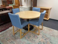 A circular pine topped table on a metal pedestal together with a set of four dining chairs