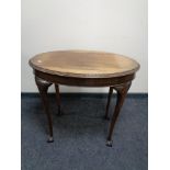 An oval Edwardian mahogany occasional table on claw and ball feet.