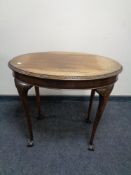 An oval Edwardian mahogany occasional table on claw and ball feet.