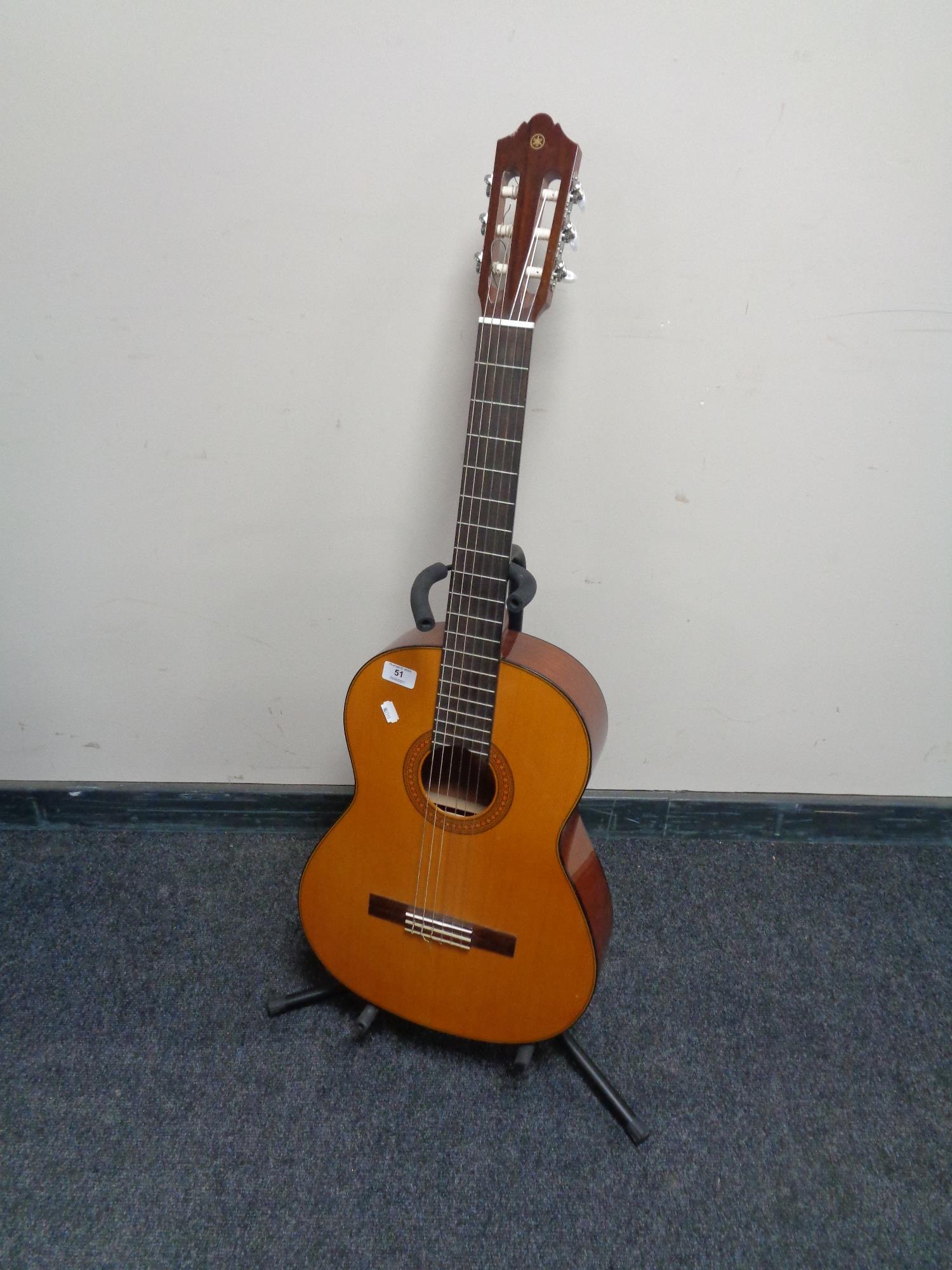 A Yamaha acoustic guitar on stand.