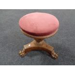 A Victorian mahogany circular revolving dressing table stool upholstered in a pink dralon.