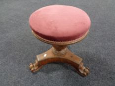 A Victorian mahogany circular revolving dressing table stool upholstered in a pink dralon.