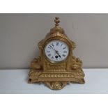 An antique French gilt mantel clock with enamelled dial