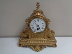 An antique French gilt mantel clock with enamelled dial