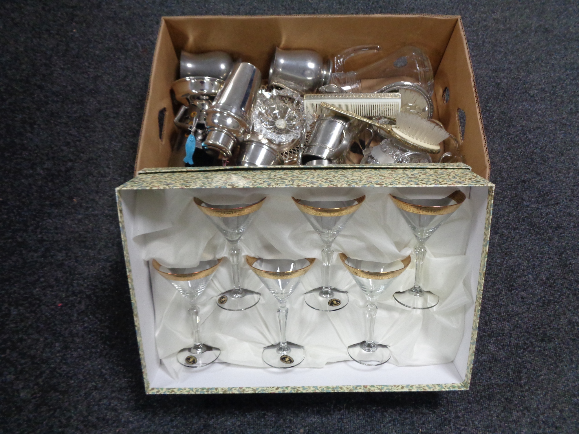 A box containing assorted glassware and metal ware to include tankards, cocktail shaker,