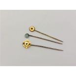 Three gold pins, two marked 15ct and set with diamond and ruby,