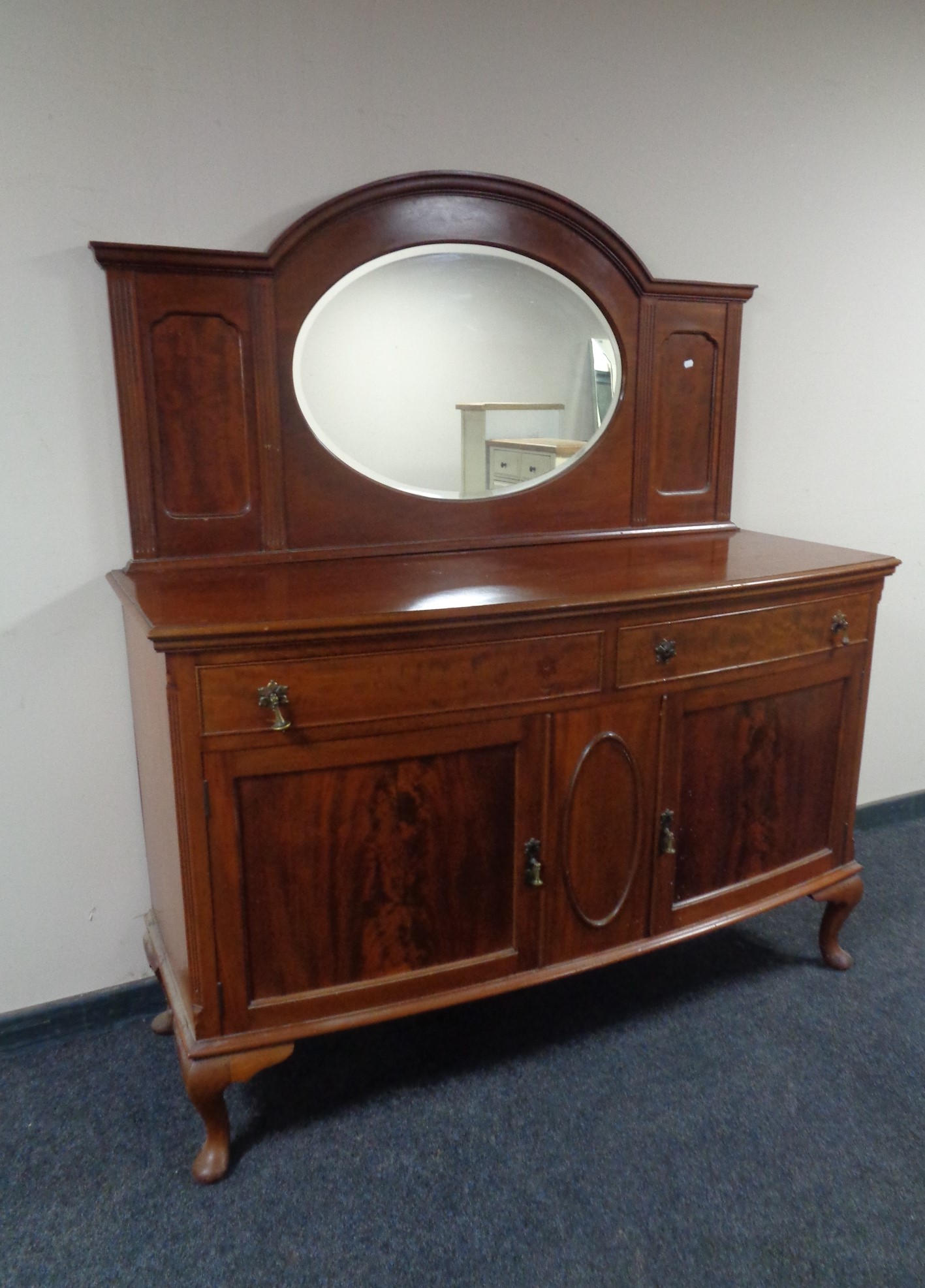 A mahogany bow fronted Queen Anne style mirror backed sideboard