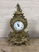 An ornate French brass mantel clock with key