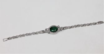 A 14ct white gold emerald and diamond bracelet, the oval-cut emerald weighing approximately 3.