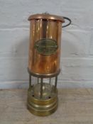 A brass and copper Ashington Colliery miner's lamp (reproduction).