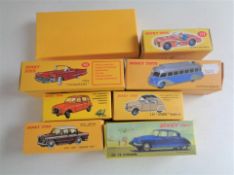 A box containing seven boxed Dinky Atlas edition cars together with boxed Atlas edition road signs.