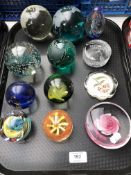 A tray containing twelve assorted glass paperweights to include globes,