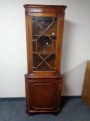 A Regency style glazed corner display cabinet fitted with cupboard beneath