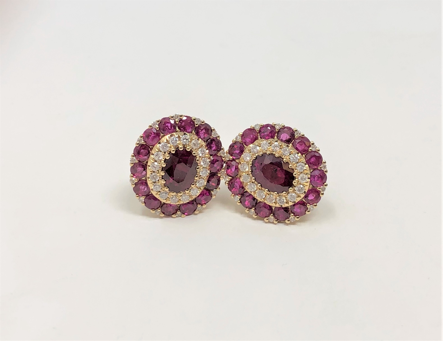 A pair of 14ct yellow gold ruby and diamond earrings featuring two oval cut rubies (1.