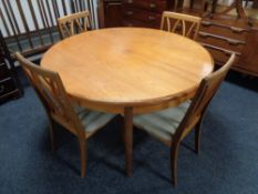 A circular teak G-plan extending table with four chairs