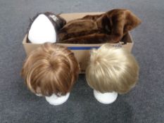 Three mannequin heads with wigs together with a box containing a simulated fur coat and a fur scarf.