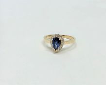 A 14ct yellow gold sapphire and diamond ring featuring centre pear cut blue sapphire (1.