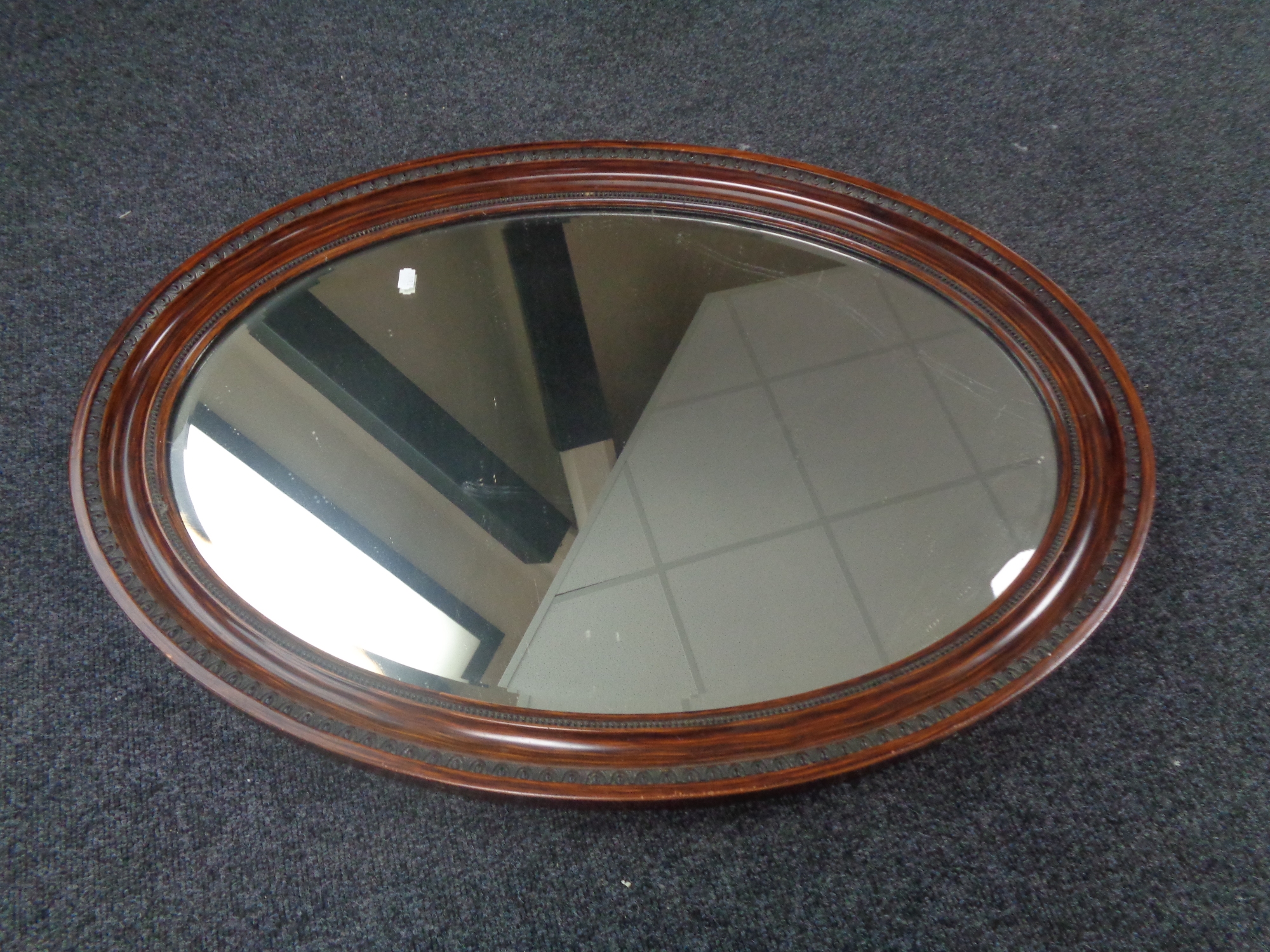 An Edwardian oval framed bevel edged mirror.