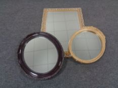 A gilt framed bevel edged mirror together with two further oval framed mirrors.