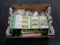 A box containing a quantity of tea and cigarette cards in albums.