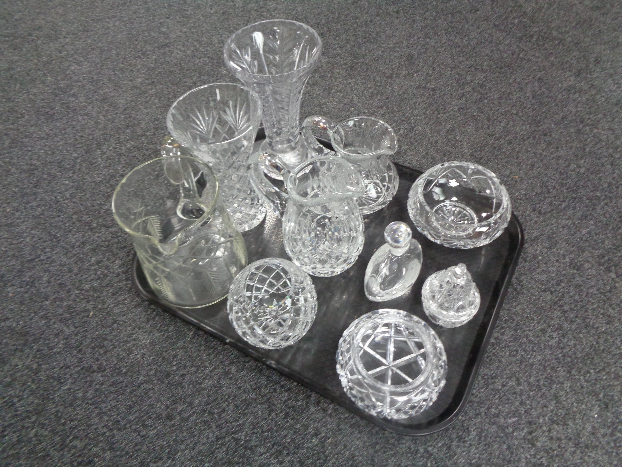 A tray containing assorted glassware to include cut glass and lead crystal vases, jugs,