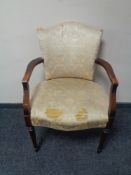 A twentieth century beech framed armchair upholstered in cream brocade fabric (for restoration)
