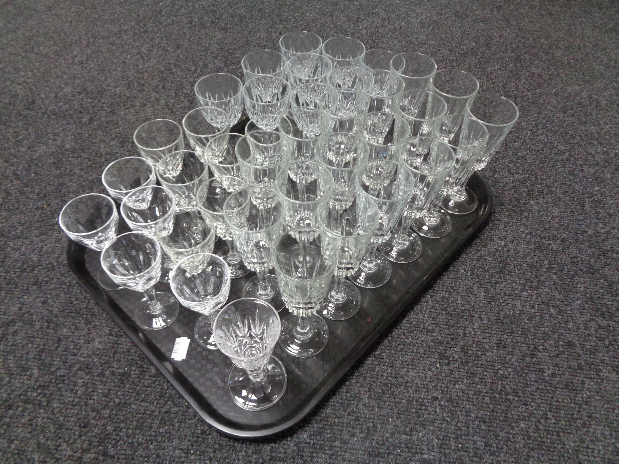 A tray containing a large quantity of assorted drinking glasses.