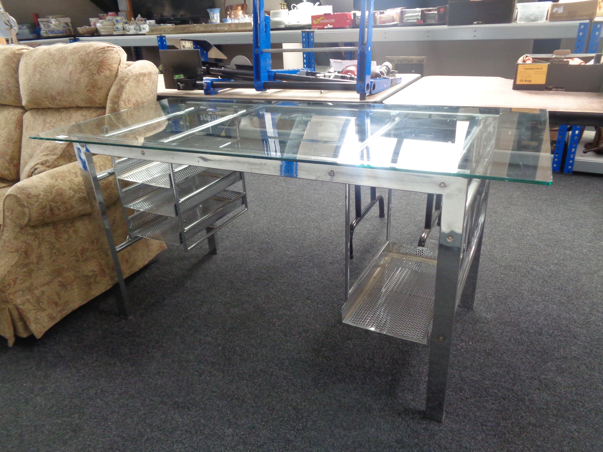 A contemporary glass topped metal based twin pedestal desk