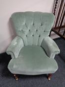 A Greensmith Victorian style armchair upholstered in a green buttoned dralon
