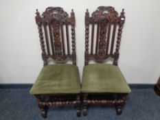 A pair of Edwardian heavily carved oak dining chairs