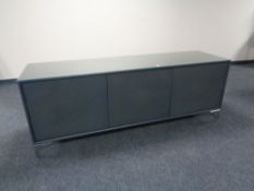 A contemporary triple door low sideboard with plate glass top,