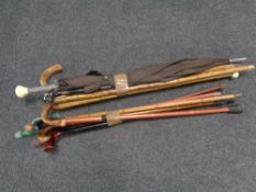 Two bundles of assorted walking sticks, parasols and practice swords.
