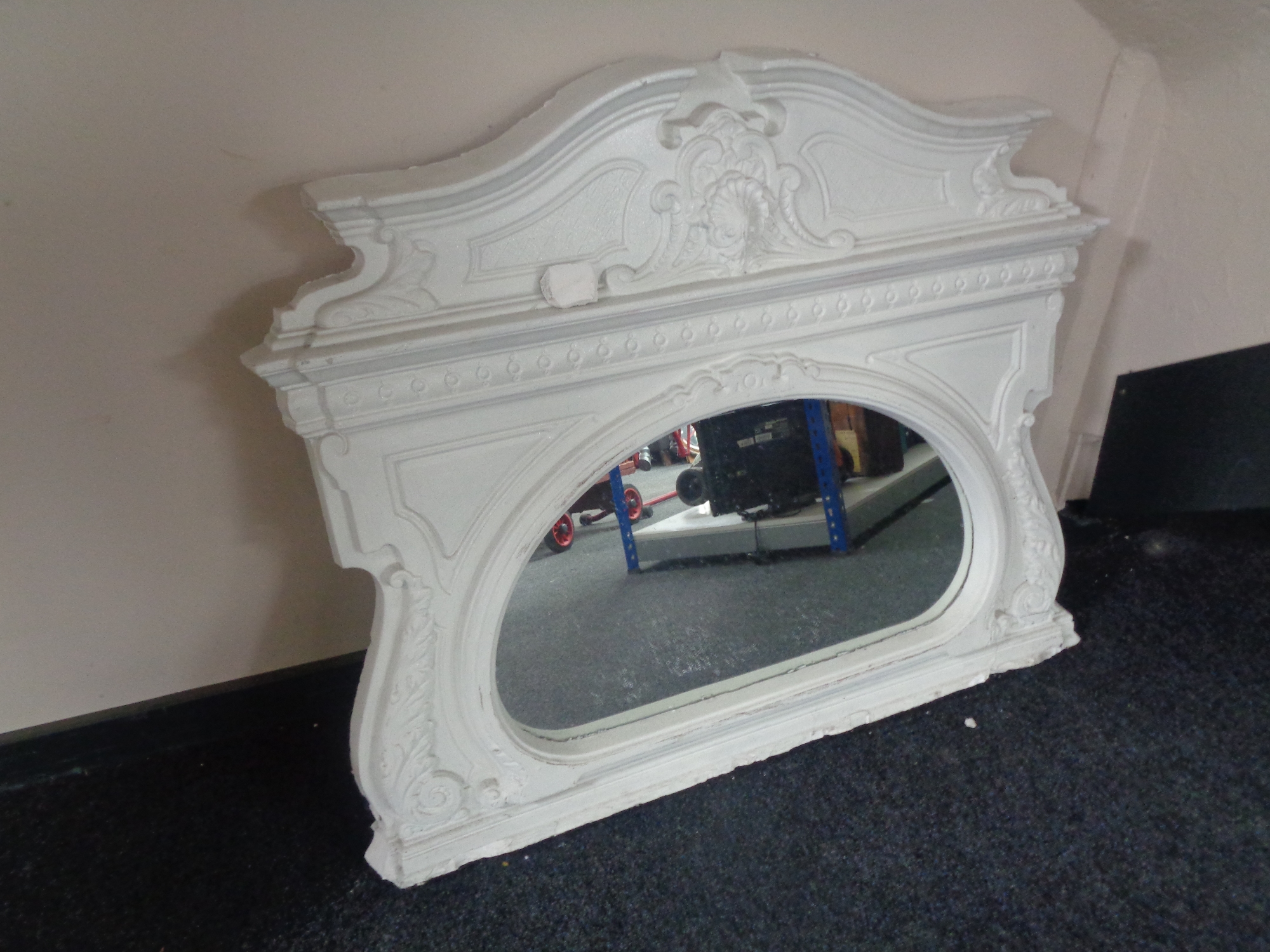A white painted plaster overmantel mirror.