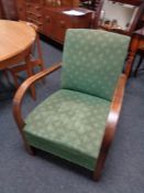 A mid century armchair upholstered in a green fabric