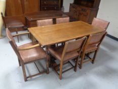 A twentieth century oak refectory dining table and six chairs in buttoned leather